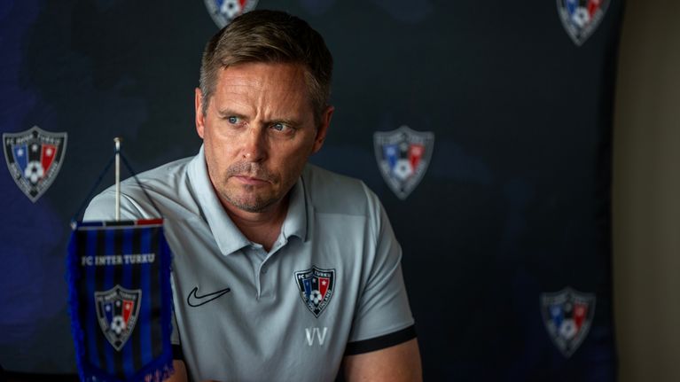 FC Inters tränare Vesa Vasa framför ett skynke med Interlogon.