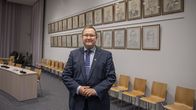 Henkilö, kaupunginjohtaja Oskari Auvinen, poseeraa kameralle kaupungintalon tiloissa. 
