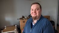 Jani-Pekka Leino seisoo olohuoneessaan muuttolaatikoita takanaan.