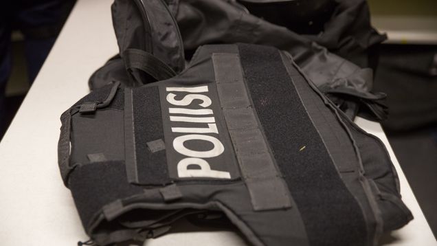 Black body armour vest with the word "poliisi" emblazoned in white on it.