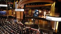 En stor guldfärgad salong fylld med människor och en stor scen. Oscarsgalan 2023.