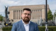 Mies katsoo kameraan.
