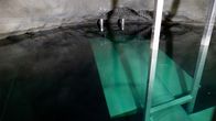 The roof of a rock cave, the surface of the water and a large white plate under the water, coloured green by the water.