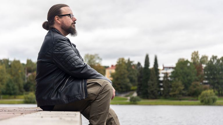 Jarkko Hakulinen istuu kivityksellä Valkeisenlammenrannalla Kuopiossa.
