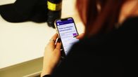 Nainen katsoo puhelimesta työvoimapalvelusivuja.