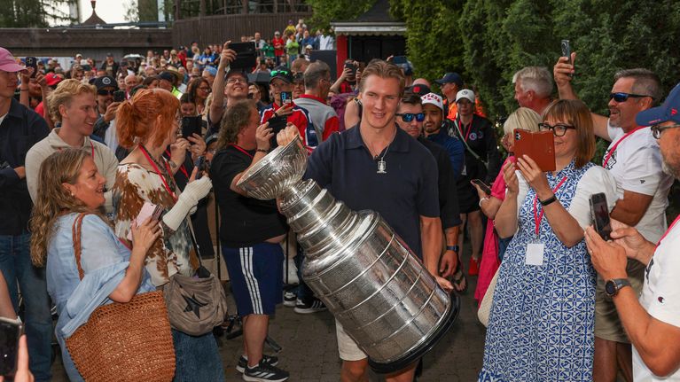 Jääkiekkoilija Anton Lundell kantaa Stanley Cup -pokaalia fanien ympäröimänä.