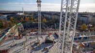 Katolta kuvattu kerrostalon työmaa, jossa nostokurkien varsia. Taustalla kaupunki ja olympiastadion.