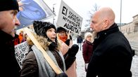 Mies ja nainen keskustelevat mielenosoituksessa.