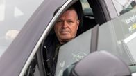 Kouvolan taksiautoilijat ry:n puheenjohtaja Marko Häkkinen istumassa taksissaan.