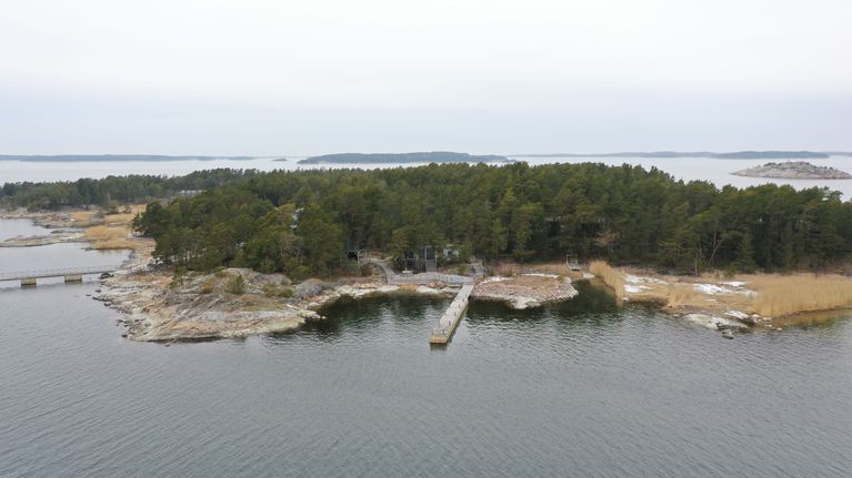 Saari josta lähtee kaksi pitkää laituria ilmasta kuvattuna.