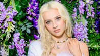 Aliisa Syrjä kukkaseinän edessä.