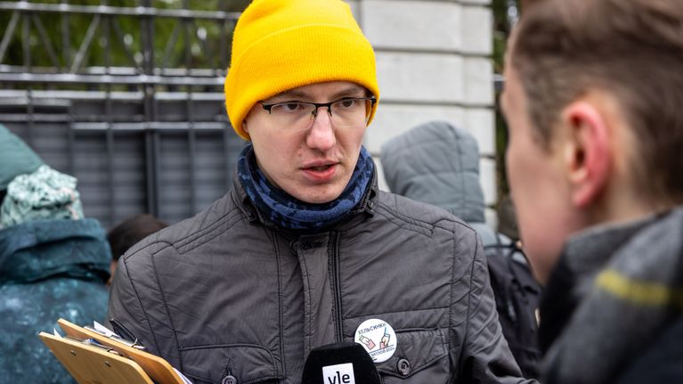 Keltapipoinen Sergei Zilin haastateltavana. Etualalla toimittaja.