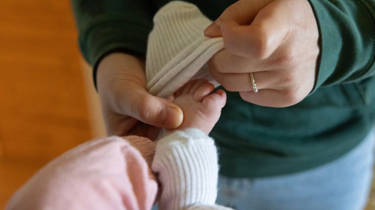 Vauvalle laitetaan sukkaa.