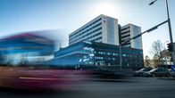 Bussiliikenne kulkee vilkkaasti Oulun yliopistollinen sairaalan edustalla aurinkoisena päivänä.