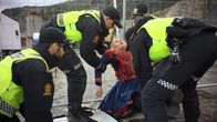 Poliisit kantavat muusikko Ella Marie Hætta Isaksenia pois Nussirin kaivosalueelta.