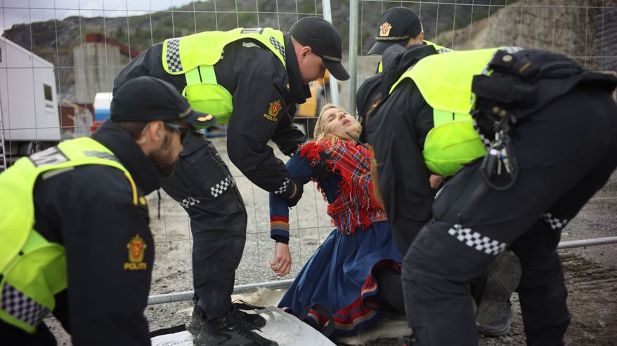Poliisit kantavat muusikko Ella Marie Hætta Isaksenia pois Nussirin kaivosalueelta.