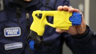 Poliisin keltainen etälamautin poliisin kädessä.