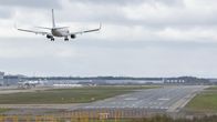 Jet passenger plane landing, approaching the runway of an airport.