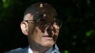 Kunihiko Sakuma lähikuvassa. Lehtien varjot näkyvät kasvoilla.