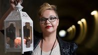 Kirjailija Salla Simukka kynttilälyhty kädessään