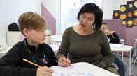 Karsikon koulun 3A-luokan opettaja Merja Jukarainen näyttää oppilas Lenni Korpisalolle, miten matematiikantehtävä ratkaistaan.