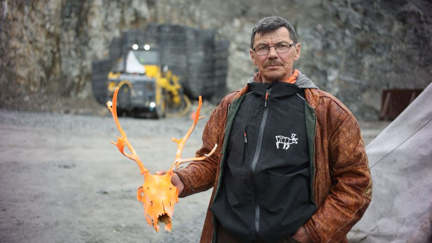 Poronhoitaja Nils Mathis Sara pitelee kädessään maalattua poron pääkalloa.