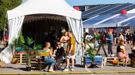 Baariteltta Flow-festivaaliella. Ihmisiä istuu sen edustalla.
