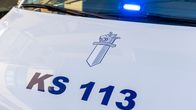 Poliisiauton konepelti ja tuulilasin alakulma. Sininen valo lasin alareunassa.