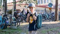 Kaarlo Turunen katsoo kameraan. Taustalla on polkupyöriä ja koululaisia.
