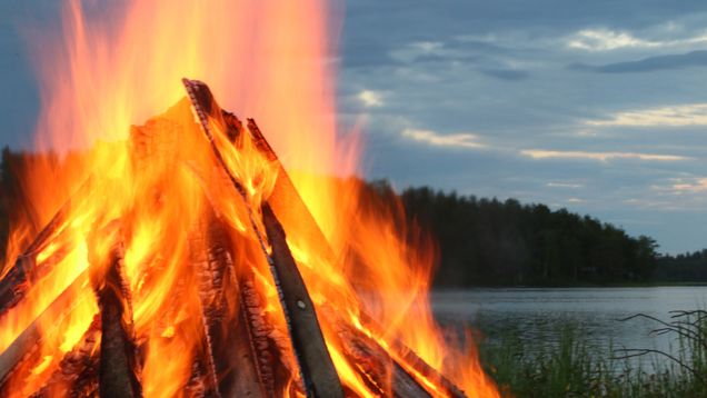 Juhannuskokko palaa järven rannalla.