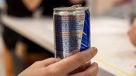 Nuori henkilö pitää kädessään energiajuomatölkkiä.