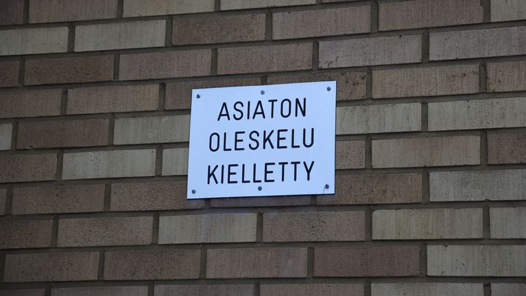 Entisen Lauritsalan apteekin ulkoseinällä oleva kientokyltti (asiaton oleskelu kielletty).