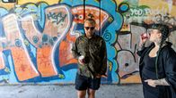 Kotkan kaupungin kesätaiteilijat Toni Lahti ja Eka Kosonen alikulkutunnelissa. Taustalla graffiteja.