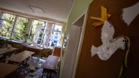 Shows a school classroom that was damaged after Russian drone attacks. Glass from broken windows is seen on the floor and on desks.