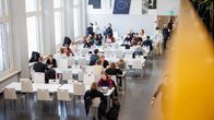 Students eating in a brightly lit cafeteria.