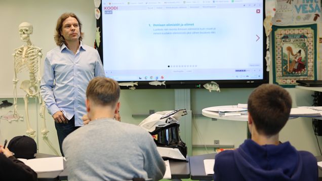 Opettaja ja oppilaita oppitunnilla.