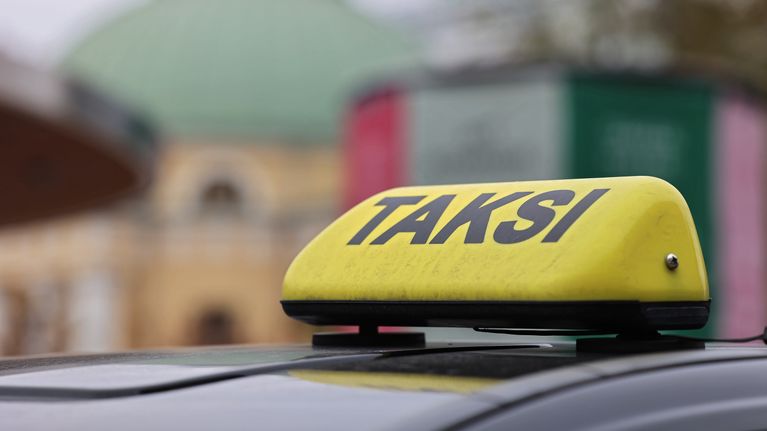 Taksin katolla oleva kyltti lähikuvassa.