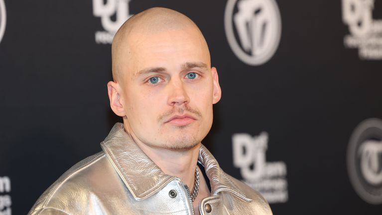 Rap-artisti Gettomasa henkilökuvassa. Hän katsoo suoraan kameraan, yllään hopean värinen nahkatakki. 