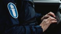 Poliisi käyttää tietokonetta poliisiautossa.