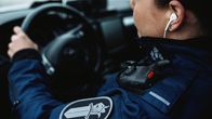 Poliisi pitää poliisiauton ratista kiinni.