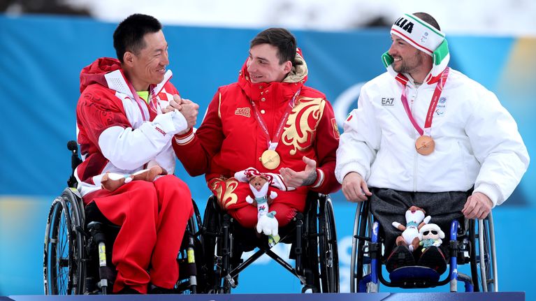 Venäjän kelkkahiihtäjä Ivan Golubkov sai onnittelut kiinalais- ja italialaiskollegoiltaan voitettuaan kultaa Italian paralympialaisissa 2026. 