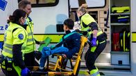 Avustustyöntekijät nostavat pyörätuolissa istuvaa poikaa ambulanssiin.
