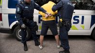 Poliisit laittavat käsirautoja pidätetyn käsiin.