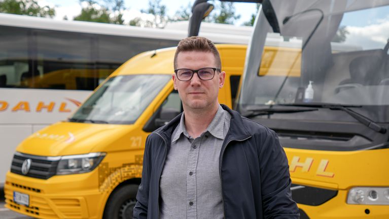 En person står framför två gula fordon.