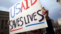 "USAID saves lives" kyltti mielenosoittajan kädessä.