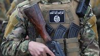 Anonyymi militanttitaistelija, joka kantaa asetta ja jolla on yllään naamiointivärityksinen univormu. Hänen taktinen liivinsä on varustettu useilla lippailla, ja liivin etupuolella on ISIS-järjestön tunnusmerkki.