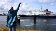 Hondius-alus saapumassa Rotterdamin satamaan. Etualalla henkilö heiluttaa laivalle.