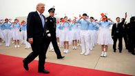 Donald Trump kävelee punaisella matolla.