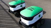 Two green and white delivery robots.