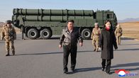Kim Jong-Un ja hänen tyttärensä Kim Ju Ae kävelevät kohti kameraa. Taustalla raketinheitinauto ja sotilaita.